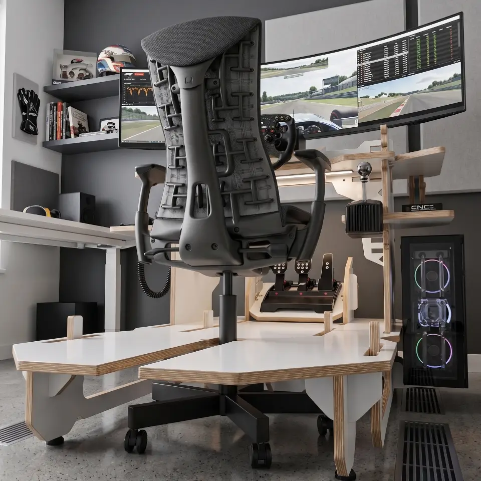 A modern, white melamine sim racing cockpit with exposed plywood edges in a bright, organized home office setup, viewed through a window showing clear skies.
