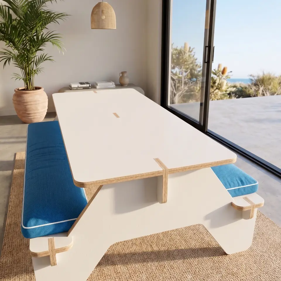 A modern XL picnic table with white melamine surfaces and exposed plywood edges, designed for CNC manufacturing, set in a bright Australian patio.